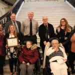 people smiling in front of stairs