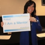a woman holding a 'I am a Mentor' sign