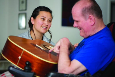 A woman using music therapy with her patient.
