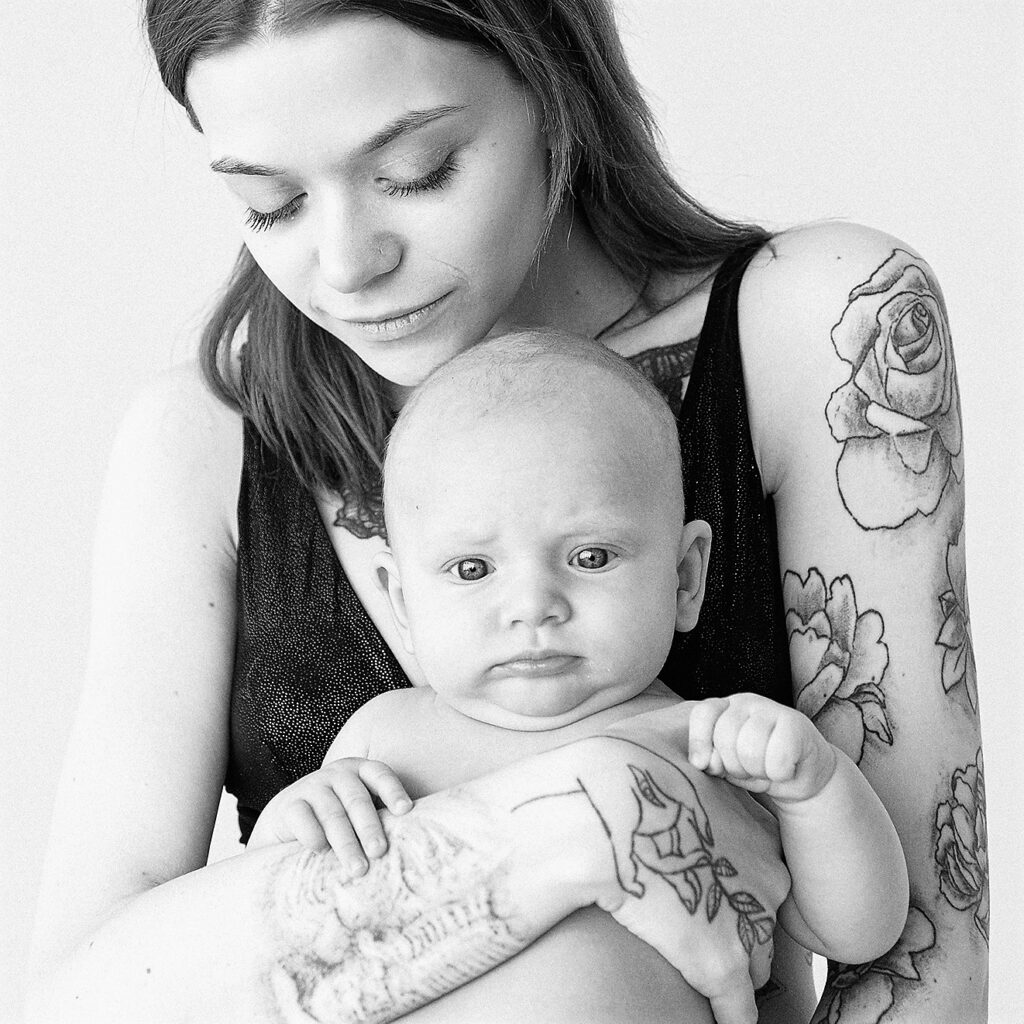 Tattooed mom holds infant child